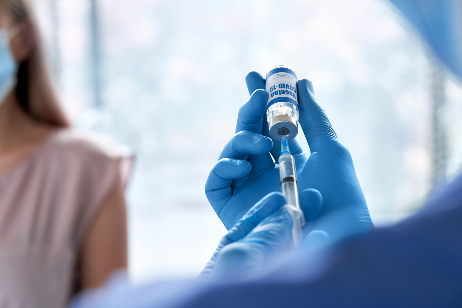 Male Doctor Wearing Gloves Holding Syringe Taking Coronavirus Vaccine Dose From Vail Preparing For C